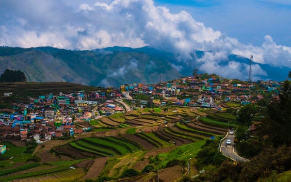 Mist rising off forested hills and terraced fields in Northeast India at dawn