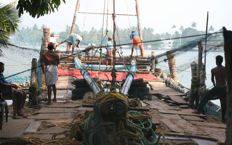 Cantilevered Chinese fishing nets silhouetted against the water at dusk in Fort Kochi